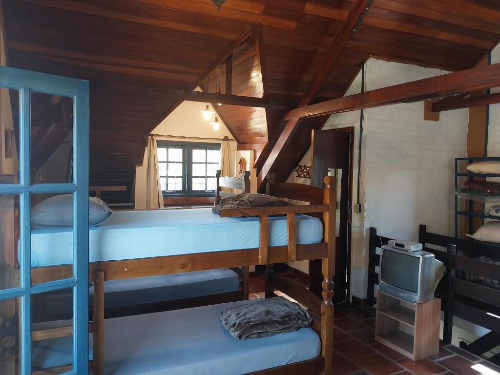 Pokój z 2 łóżkami piętrowymi i telewizorem w obiekcie Passa Quatro- CASA INTEIRA RUSTICA para até 9 pessoas w mieście Passa Quatro