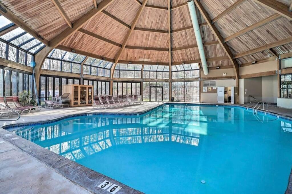 a large swimming pool in a building with a wooden ceiling at Ian's Camelback House in Tannersville