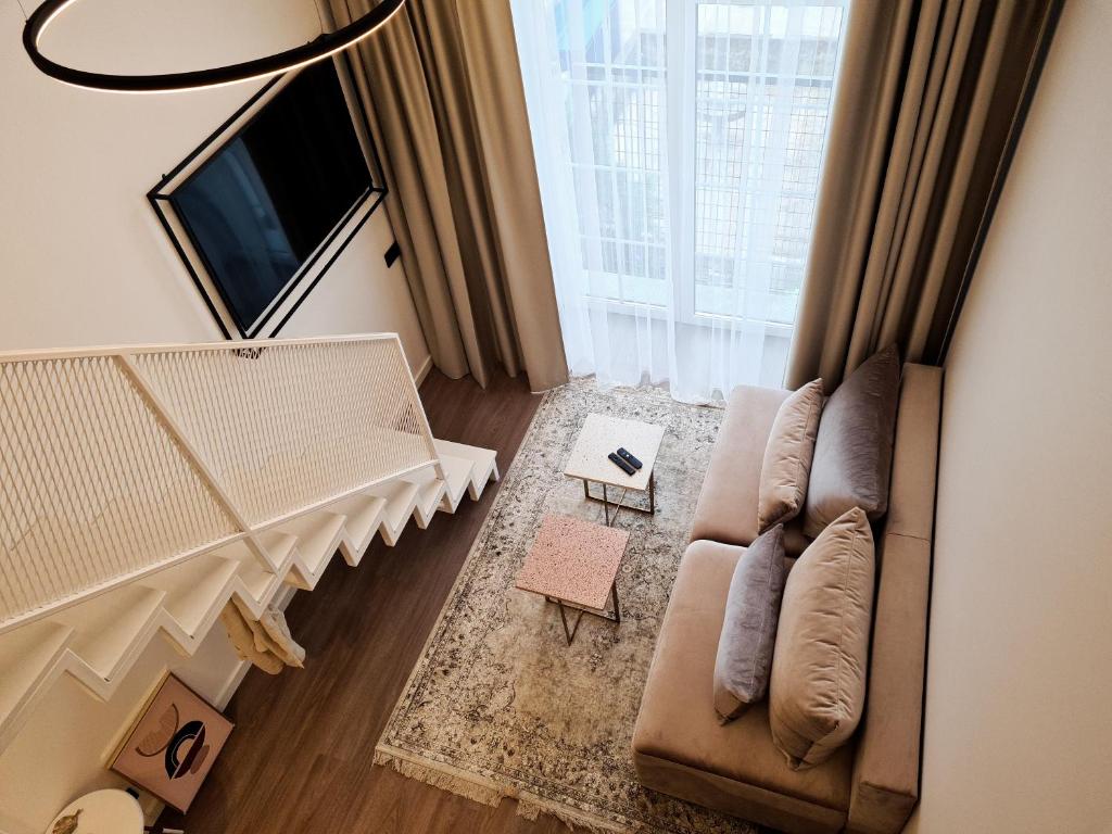 uma sala de estar com um sofá e uma grande janela em Stay in Kaunas & Radio City - Free Parking em Kaunas
