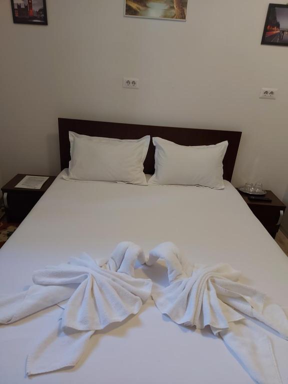 a white bed with a blanket on top of it at Casa Stefan Galati in Galaţi