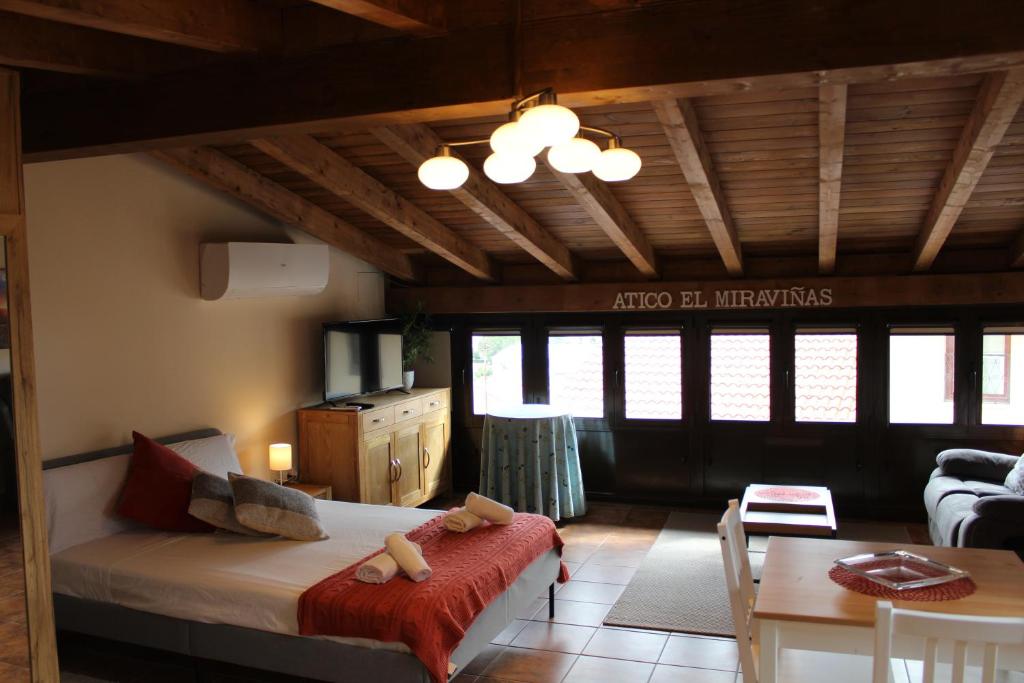 Sala de estar con cama y mesa en Atico El Miraviñas, en Labastida