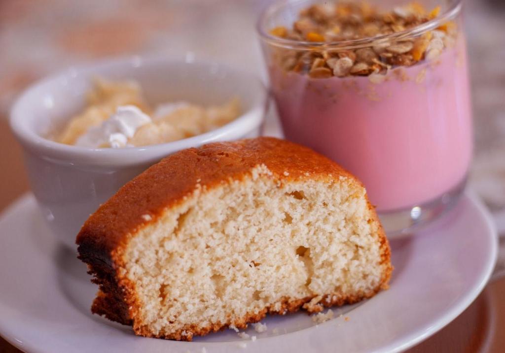 ein Stück Kuchen auf einem Teller neben einem Drink in der Unterkunft Hotel Ermitage in Santana do Livramento