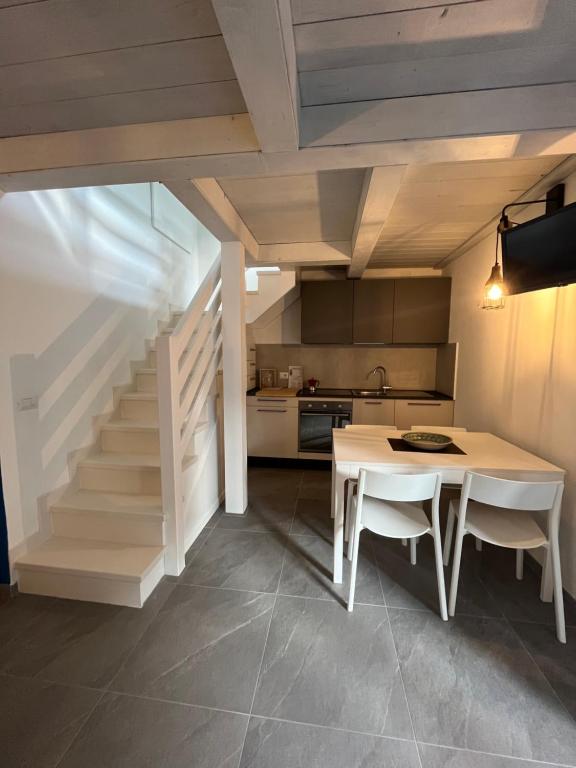 een keuken en eetkamer met een tafel en een trap bij Chalet del mare in Cervia