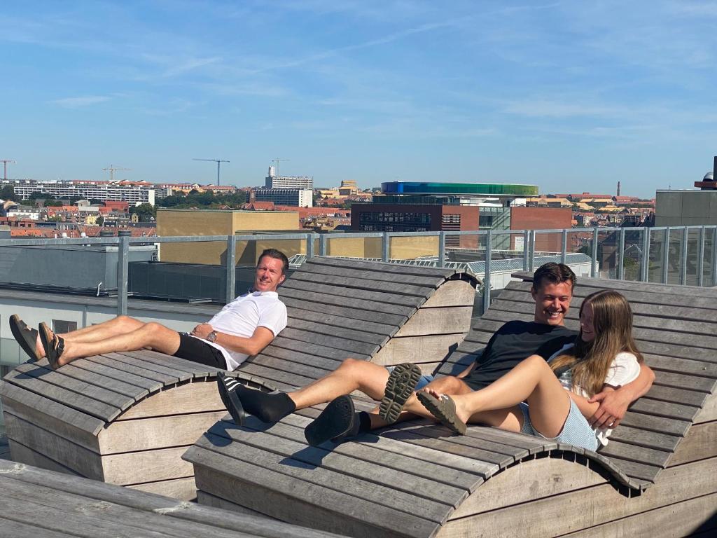 a group of people sitting on a roof at Central Apartment with Panorama Rooftop & Free Parking in Aarhus