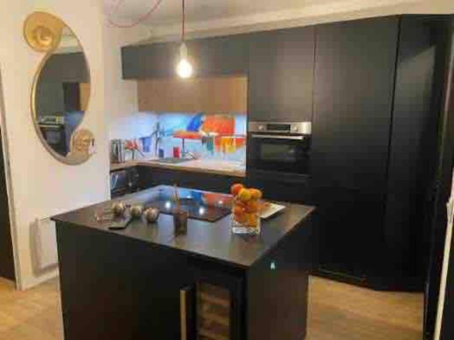 a kitchen with a black island in a room at appartement en résidence vue mer , piscine… in Six-Fours-les-Plages