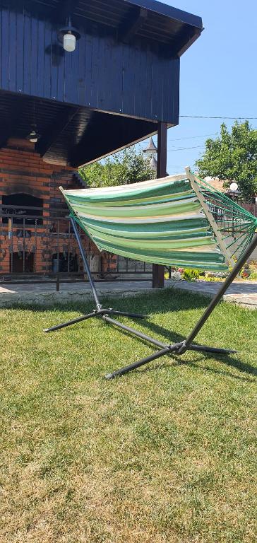 a hammock sitting on the grass in front of a building at Casa Sofia in Bălţăteşti