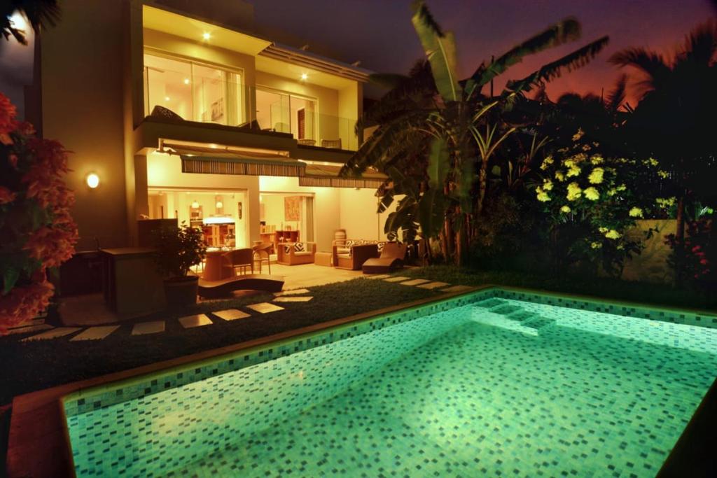 - une piscine en face d'une maison la nuit dans l'établissement VILLA MIADANA, à Dzamandzar