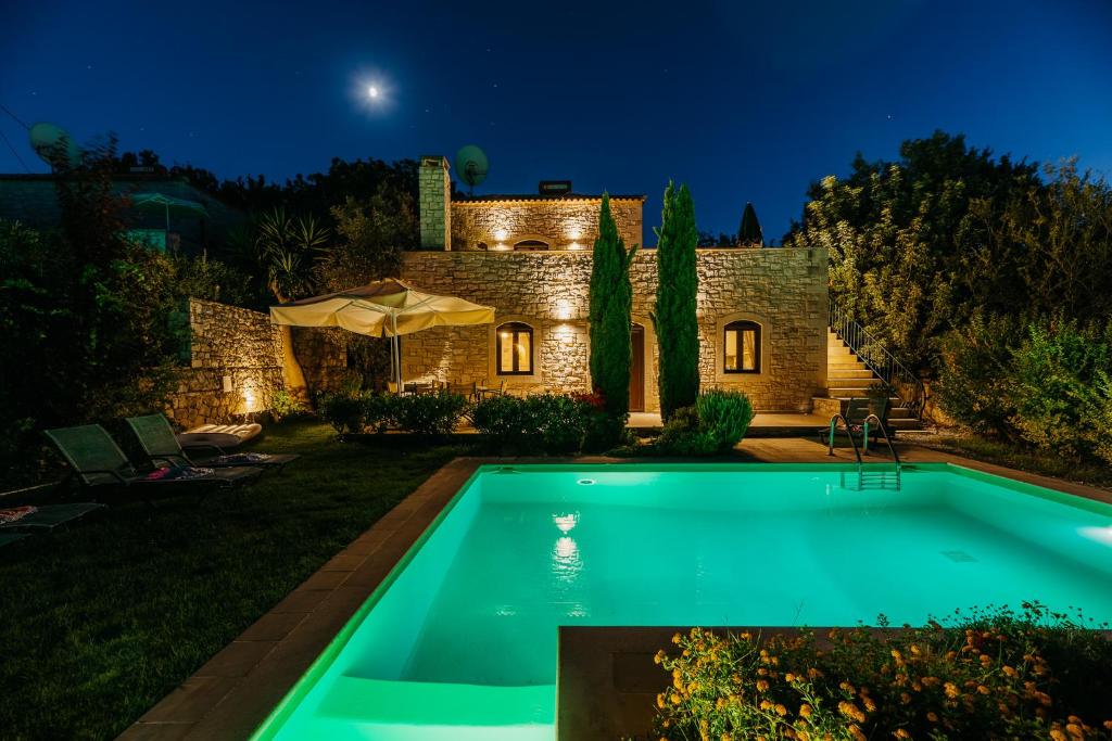 a swimming pool in front of a house at night at Villa Olympia - Villa Erato in Prinés