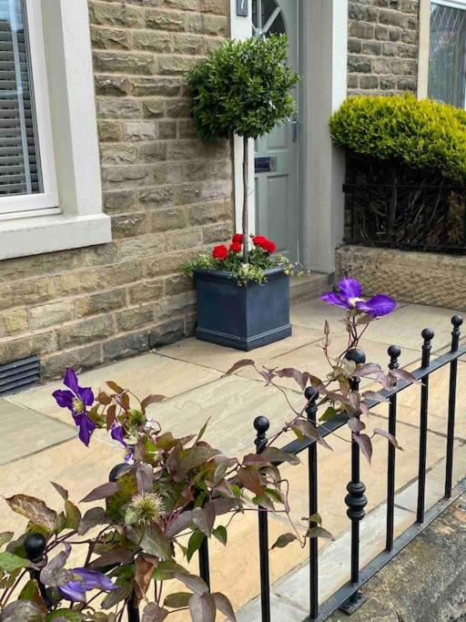 a fence with purple flowers in front of a house at Cheerful and spacious 3 bed home in Clitheroe in Clitheroe