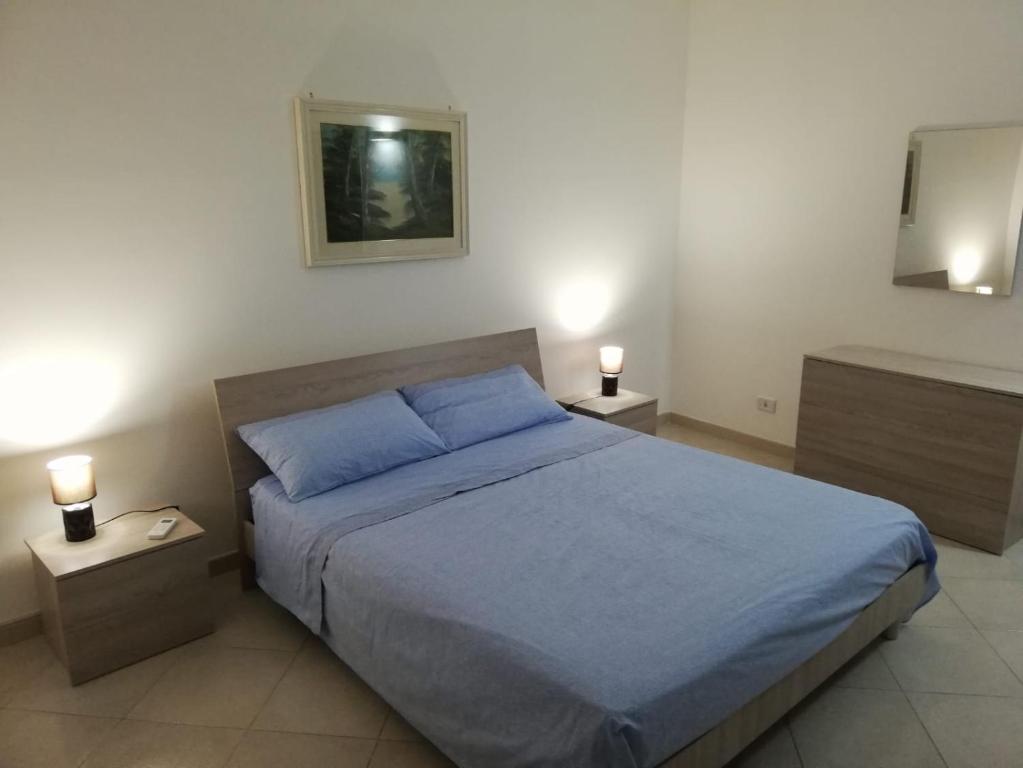 a bedroom with a blue bed and two night stands at Casa vacanze in Massafra