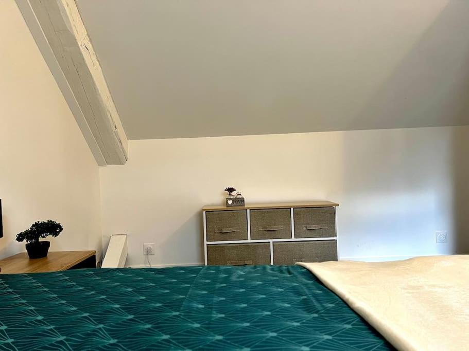 - une chambre avec un lit vert et une commode dans l'établissement La Française - 85m2, à Vierzon