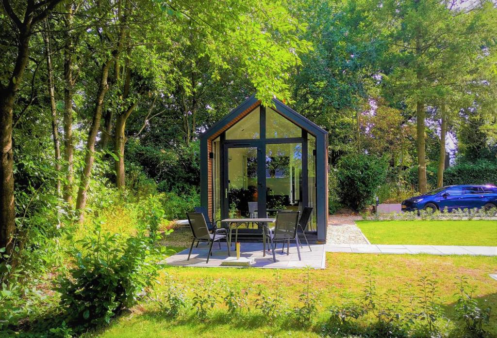 cenador con sillas y mesa en el jardín en Huisje Bloemendal, en Balkbrug