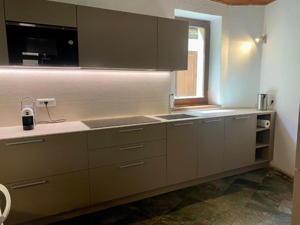 a kitchen with brown cabinets and a window at Chalet Motta in Valtournenche