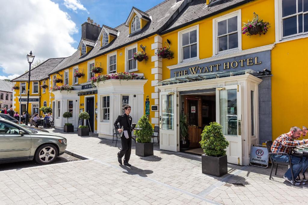 Un uomo in piedi di fronte a un edificio giallo di The Wyatt Hotel a Westport