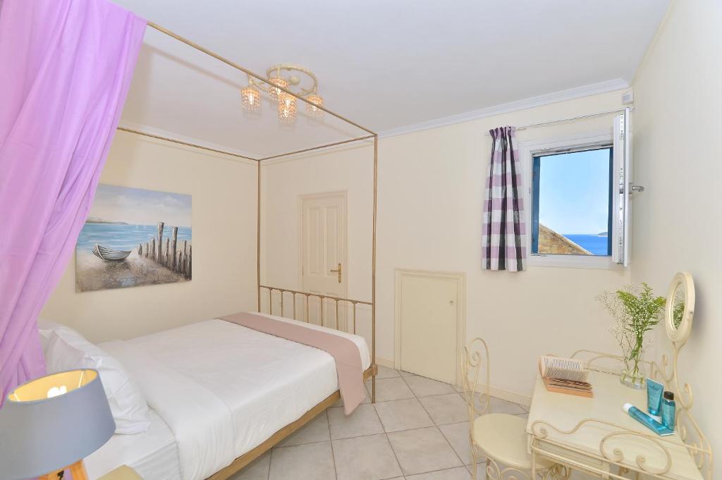 sypialnia z łóżkiem, krzesłem i oknem w obiekcie Andros Homes Sea Side Apartment & Studio w mieście Gavrion