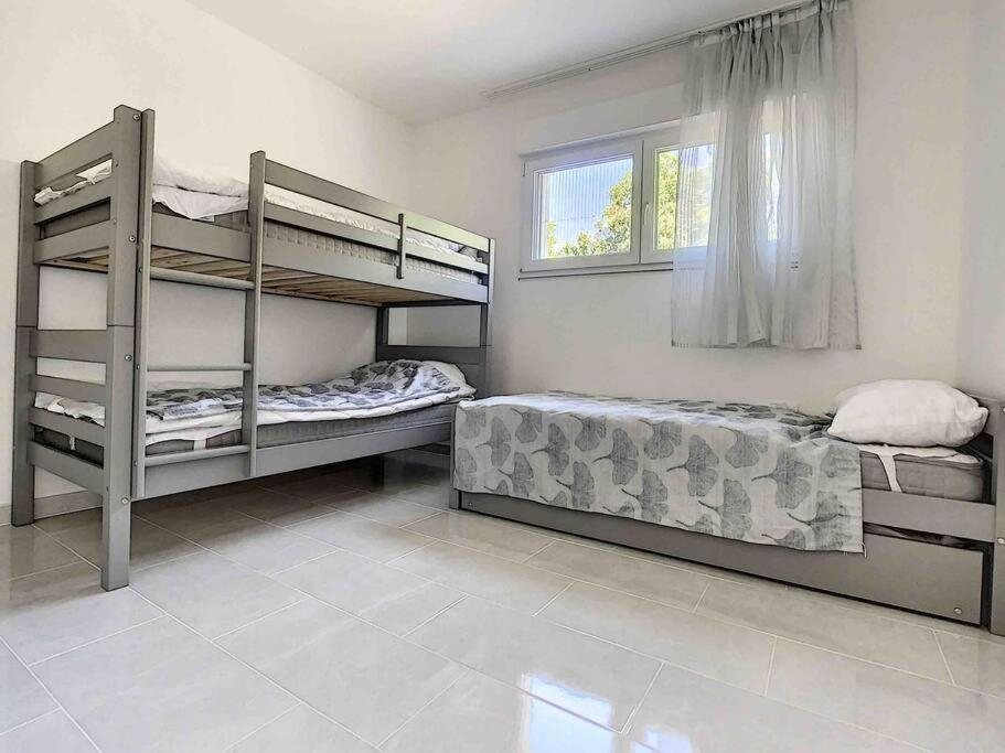 a bedroom with two bunk beds and a window at La villa petite Camargue in Saint-Louis