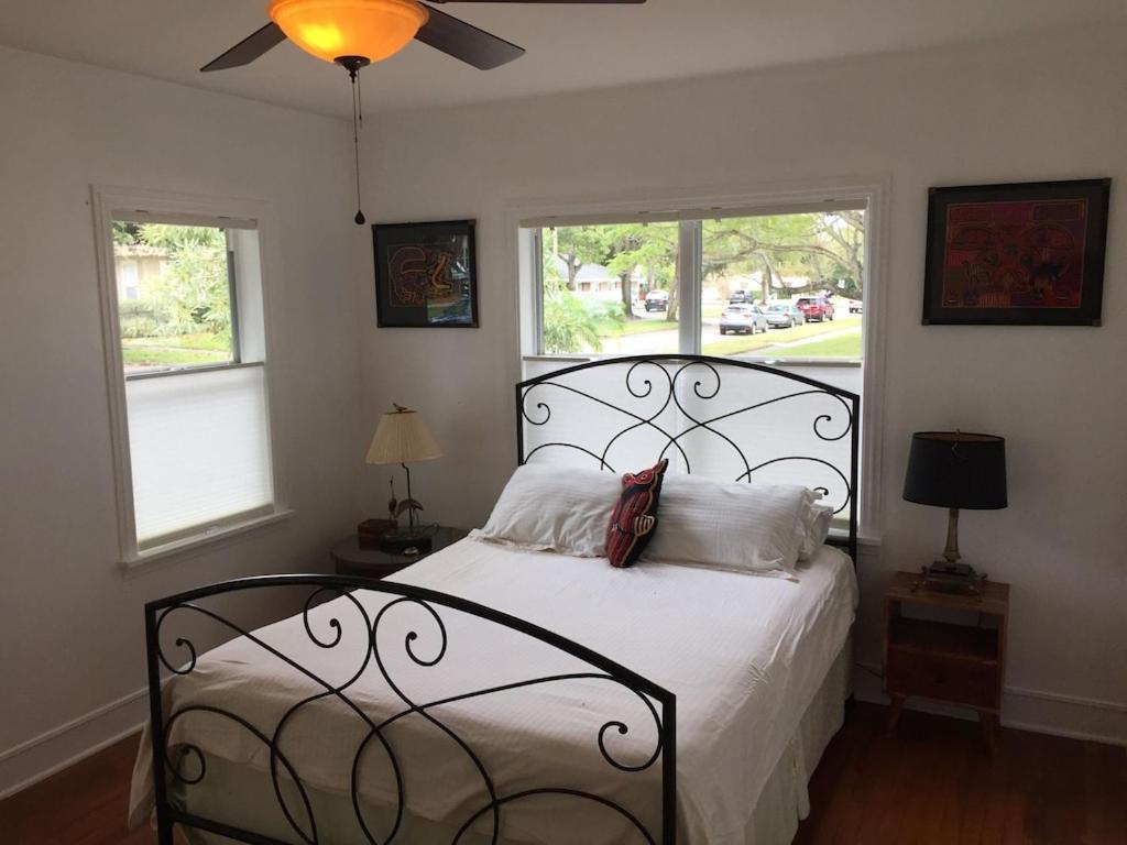 a bedroom with a white bed with a black headboard and two windows at 1620 - 5-Room Apt. with Pool & Gardens , Near Downtown in St. Petersburg