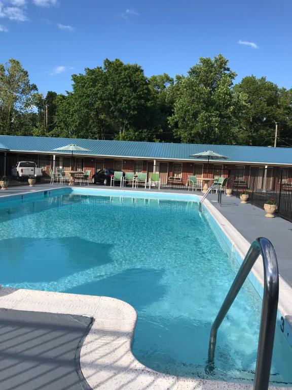 una gran piscina frente a un edificio en MERRIMAC INN & SUITES en Williamsburg