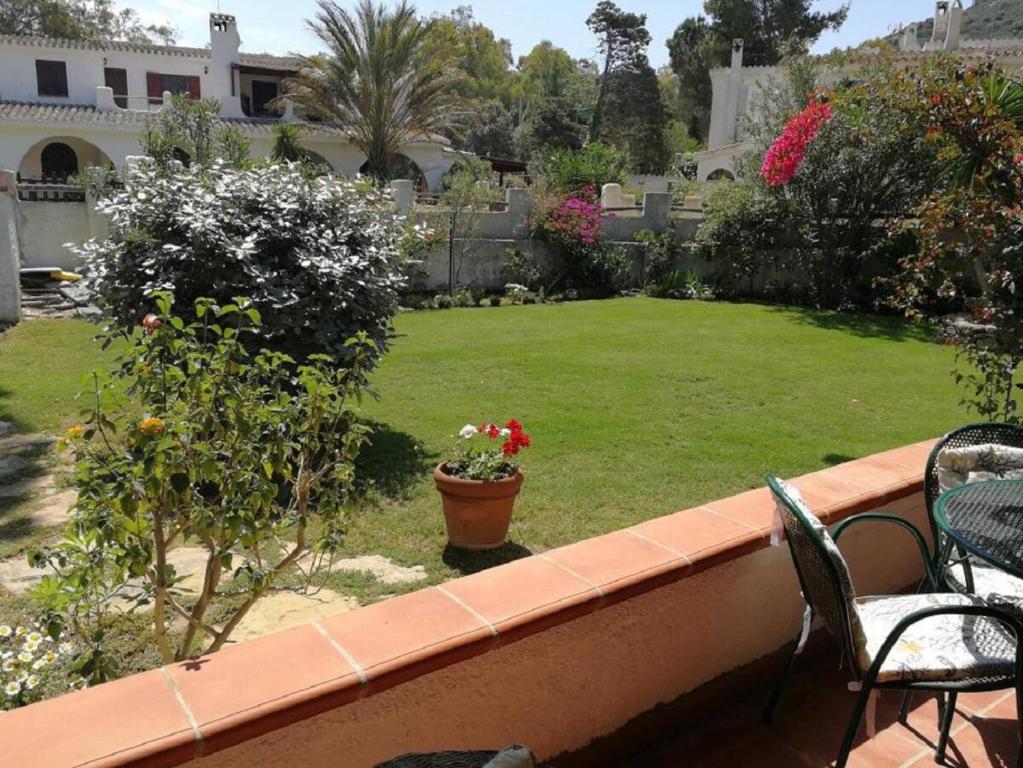 een balkon met stoelen en een tuin met een gazon bij Villa Centauro in Torre delle Stelle