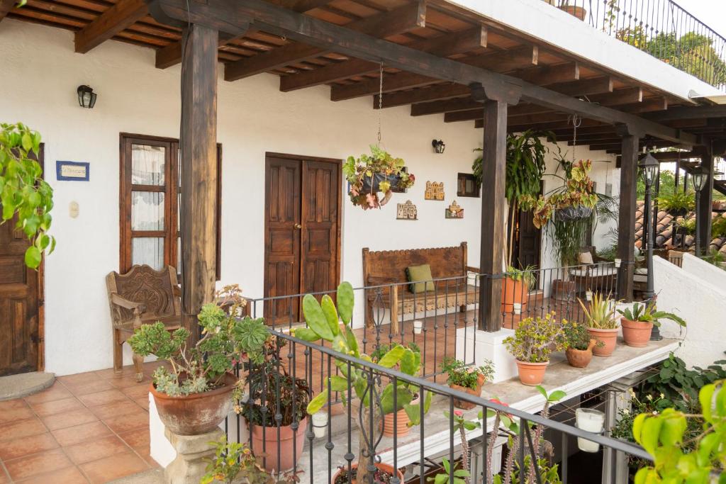 un porche avec des plantes en pot sur une maison dans l'établissement Hotel La Villa Serena, à Antigua Guatemala