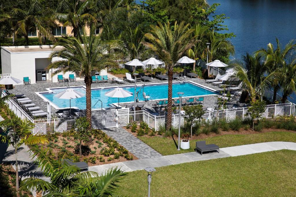 vista aerea su una piscina del resort con palme di EVEN Hotel Miami - Airport, an IHG Hotel a Miami
