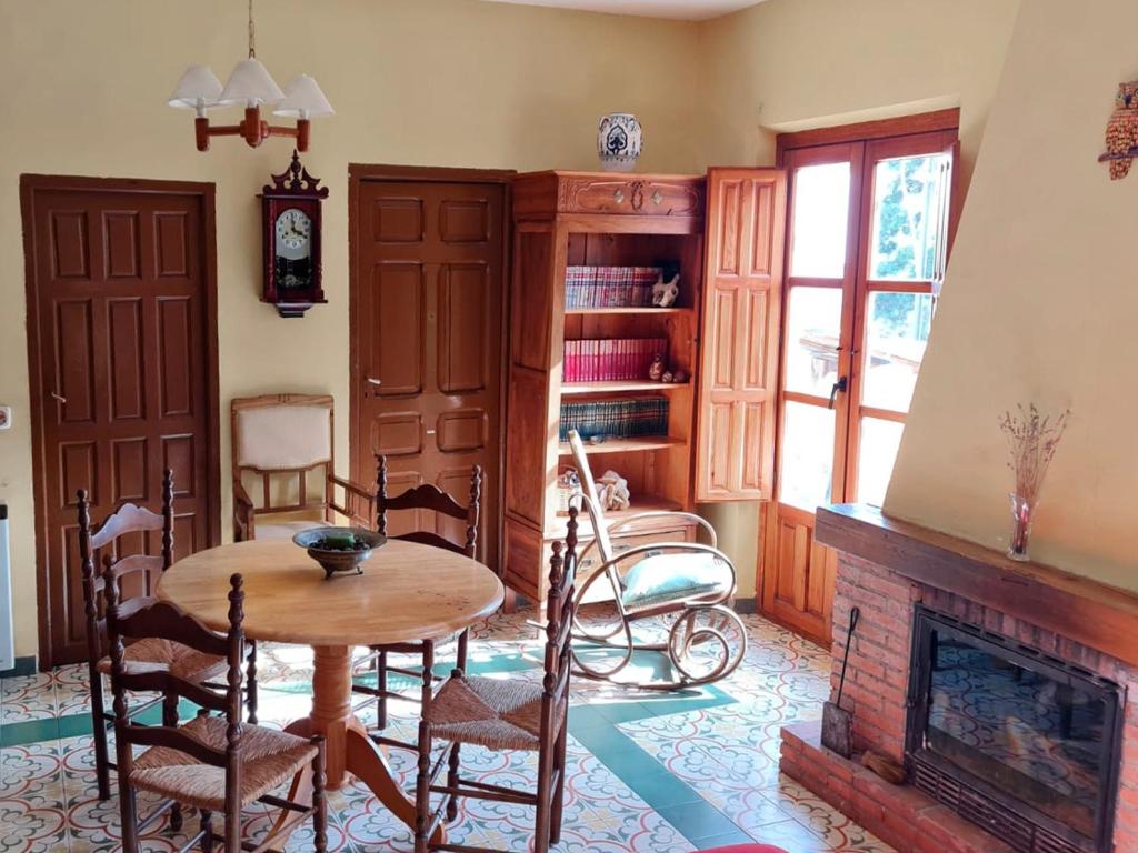 - un salon avec une table et une cheminée dans l'établissement Casa Inma, à Miraflores de la Sierra