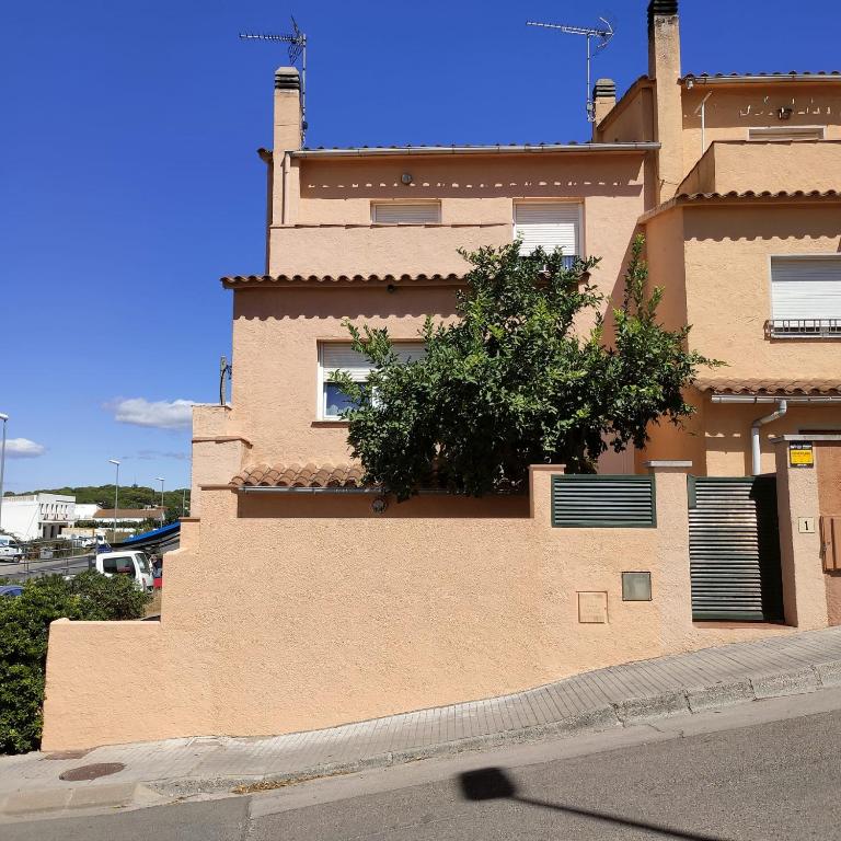 un bâtiment avec un arbre sur son côté dans l'établissement Casa Dorada, à L'Escala