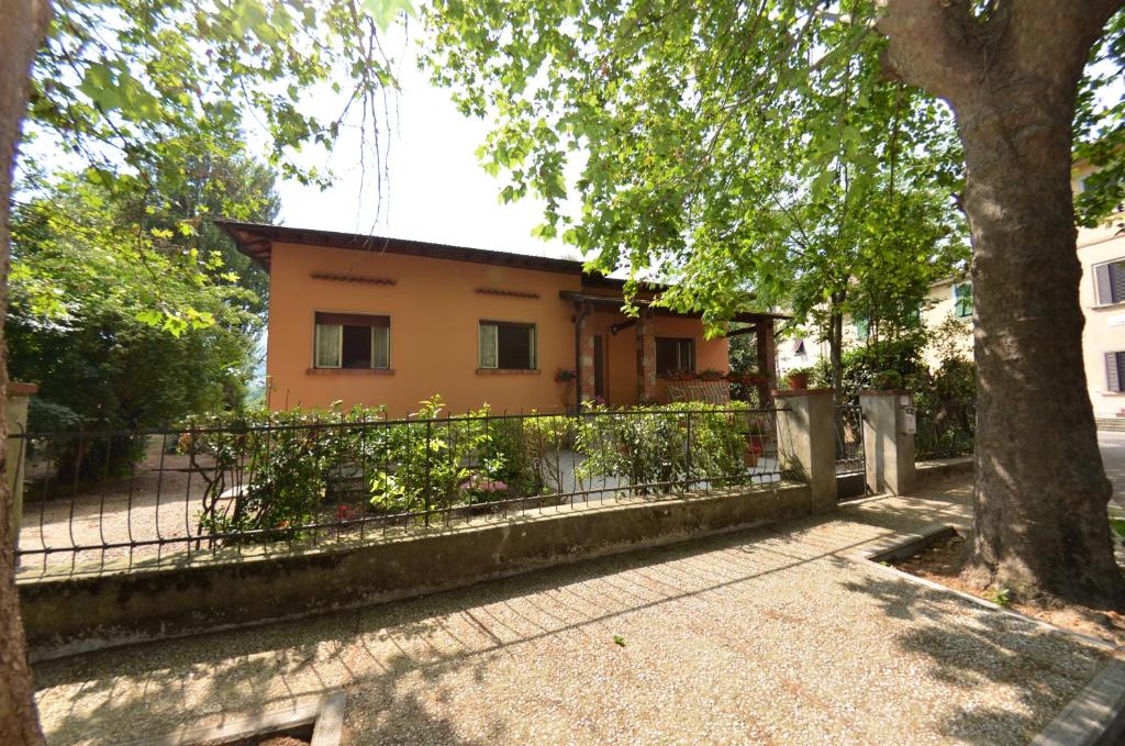 ein Haus mit einem Zaun und einem Baum in der Unterkunft Villa Elisa in Bientina