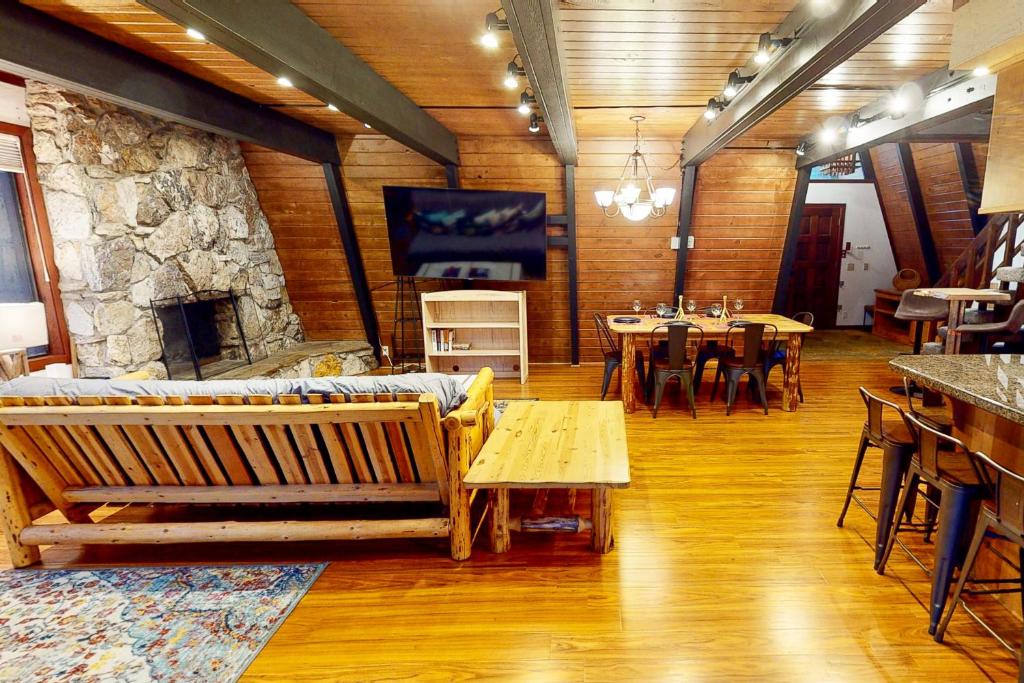 uma sala de estar com uma lareira de pedra e uma mesa e cadeiras em Chapel Grove em Tahoe City