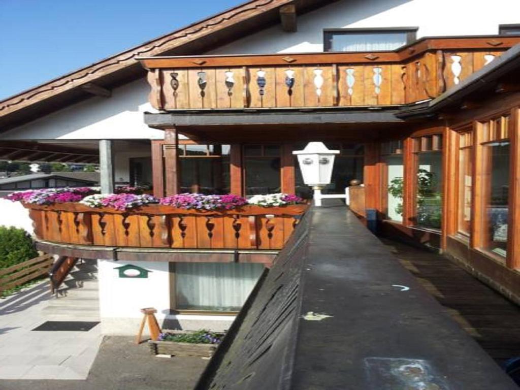 un edificio con un balcón con flores. en Pension "Dorfkrug" en Winterberg