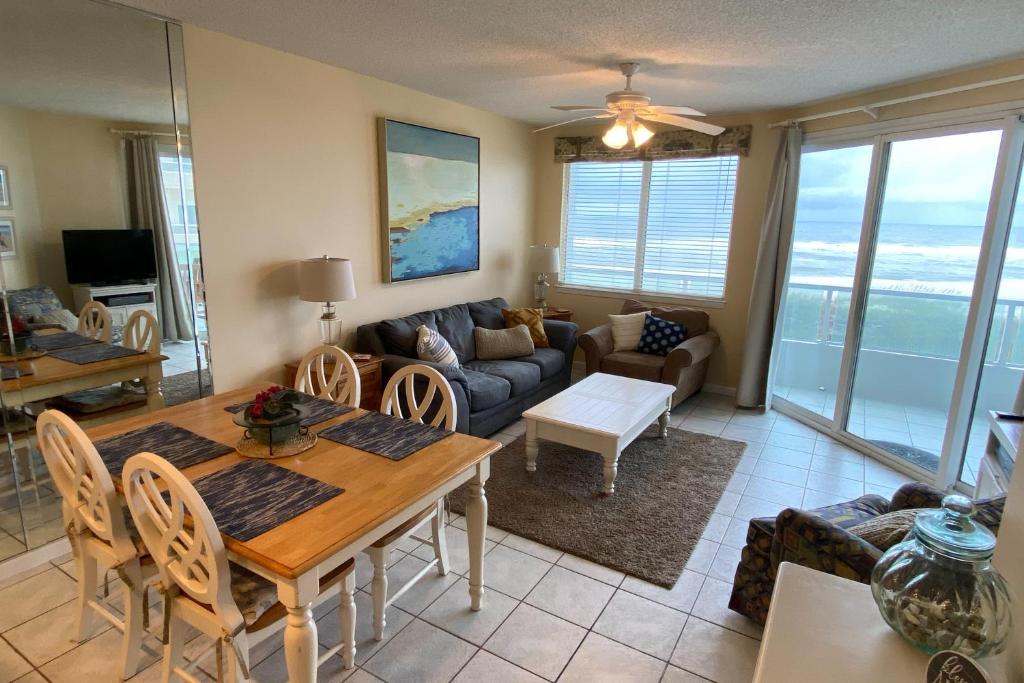 ein Wohnzimmer mit einem Tisch und einem Sofa in der Unterkunft Silver Beach 205 in Orange Beach