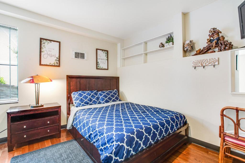 a bedroom with a bed with a blue comforter at Beacon Hill Hideaway in Seattle