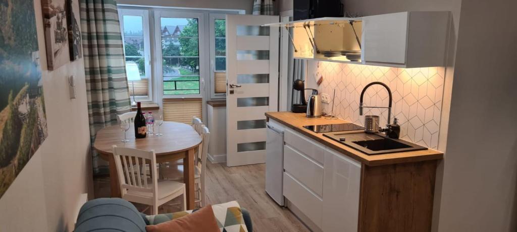 una cucina con lavandino e tavolo in una stanza di Neu Schweizerhaus 29 a Karpacz