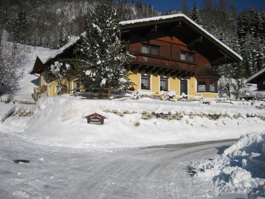 una casa cubierta de nieve delante en Ferienwohnung Hofer, en Pruggern