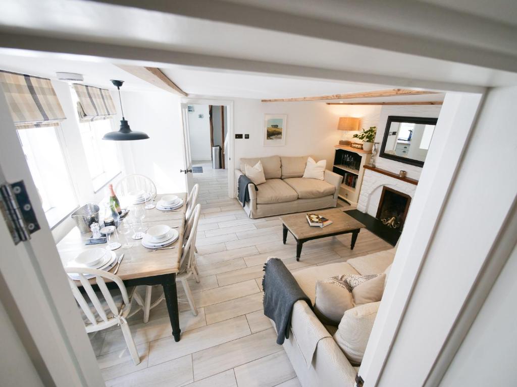 a living room with a table and a couch at Padstow Escapes - Captains Cottage in Padstow