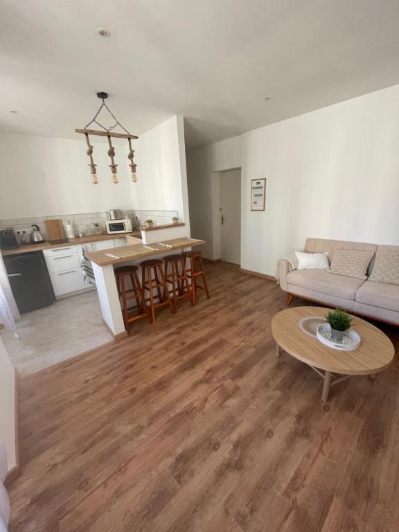 a living room with a couch and a table at BABILOC Bohème Appartement in Riez