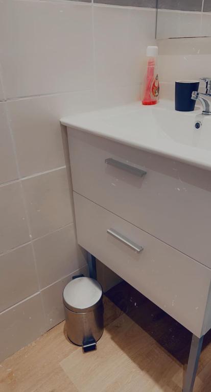 a white bathroom with a toilet under a sink at Clem in Calais