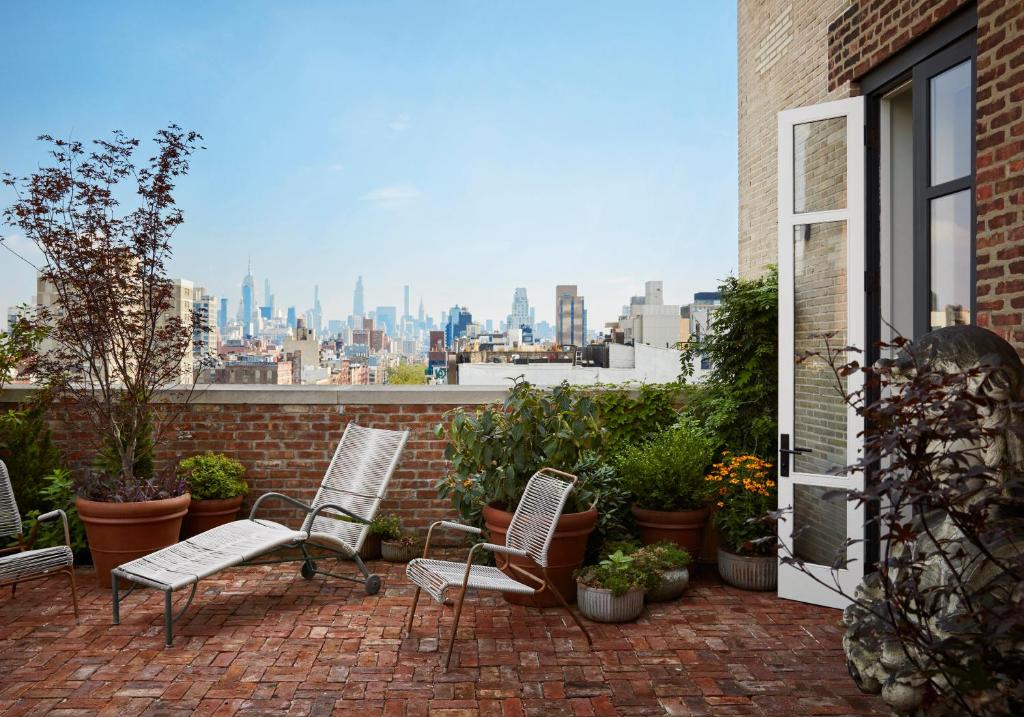 a patio with chairs and a view of the city at Nine Orchard in New York