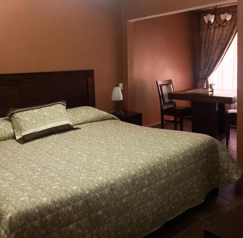 - une chambre avec un lit et un bureau dans l'établissement Villas San Francisco, à Huichapan