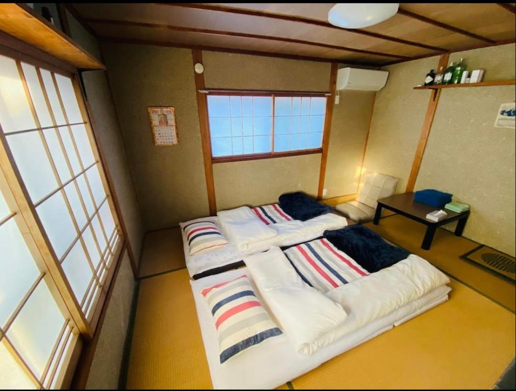 Da Fern في ساكايميناتو: غرفة صغيرة بسريرين في غرفة بها نوافذ