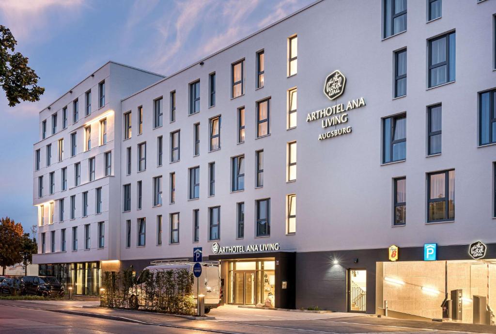 a large white building on a city street at elaya hotel augsburg in Augsburg