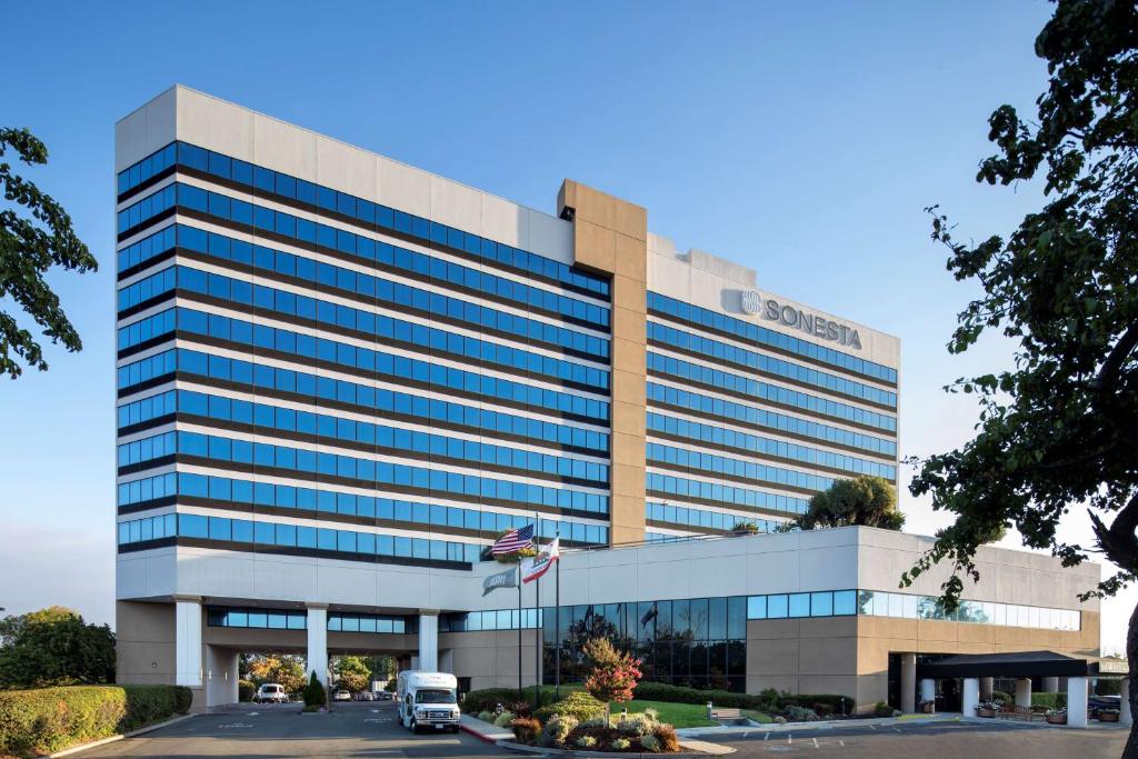 an office building with a van parked in front of it at Sonesta San Jose - Milpitas in Milpitas