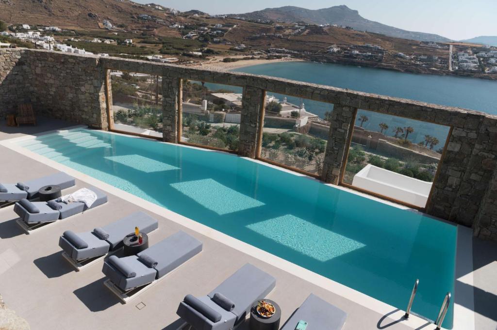 an overhead view of a swimming pool with chairs and water at Radisson Blu Euphoria Resort, Mykonos in Kalo Livadi