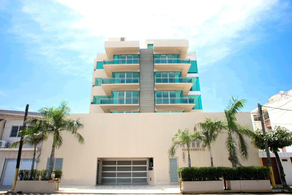 韋拉克魯斯的住宿－Terra Residencial，一座高大的建筑,前面有棕榈树