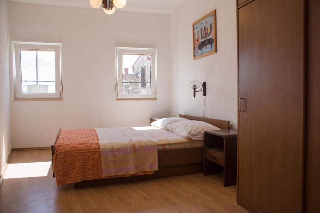 a bedroom with a bed and a dresser and two windows at Holiday house with WiFi Novi Vinodolski - 12241 in Novi Vinodolski