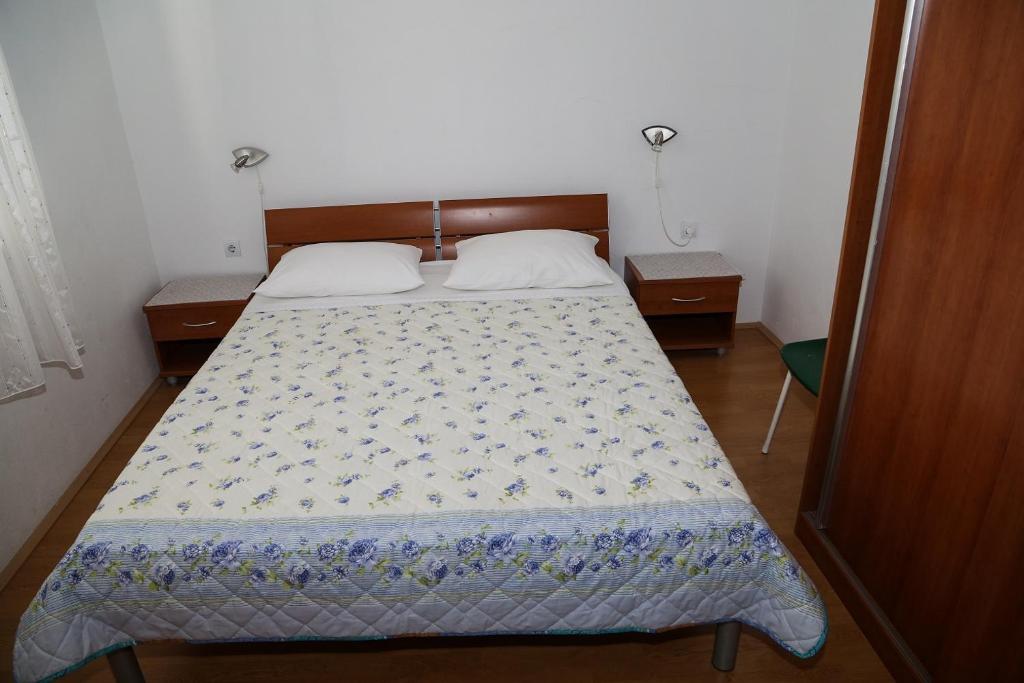 sypialnia z łóżkiem z niebiesko-białą kołdrą w obiekcie Apartments by the sea Milna, Hvar - 12244 w mieście Milna