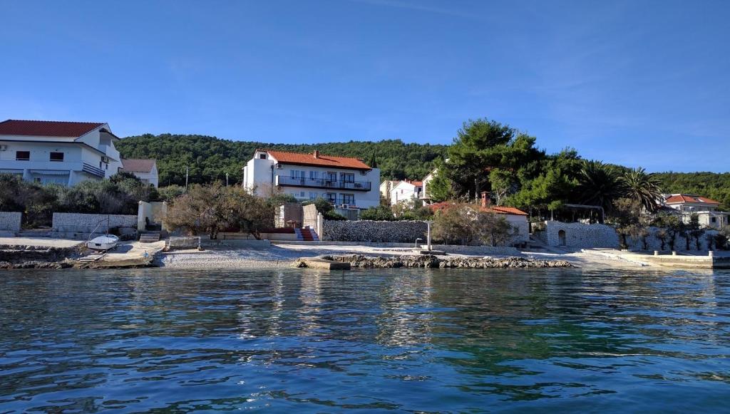a group of houses on the shore of a body of water at Apartments by the sea Slatine, Ciovo - 12274 in Slatine