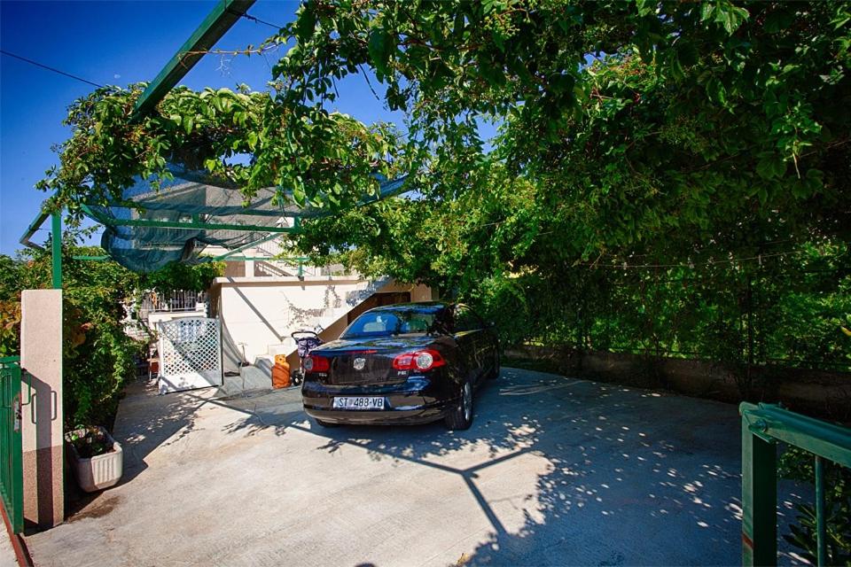 a car parked in a driveway next to a house at Apartments with a parking space Komiza, Vis - 12325 in Komiža