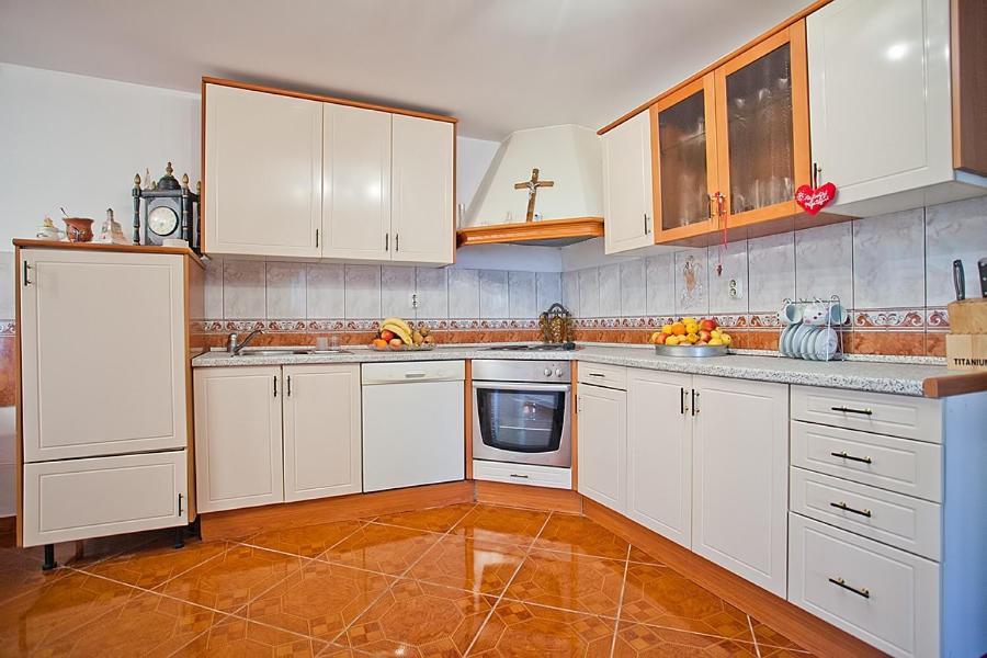 a kitchen with white cabinets and a tile floor at Apartments with a parking space Komiza, Vis - 12325 in Komiža