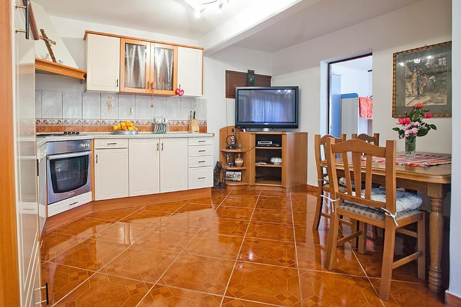 a kitchen with a table and a television in it at Apartments with a parking space Komiza, Vis - 12325 in Komiža